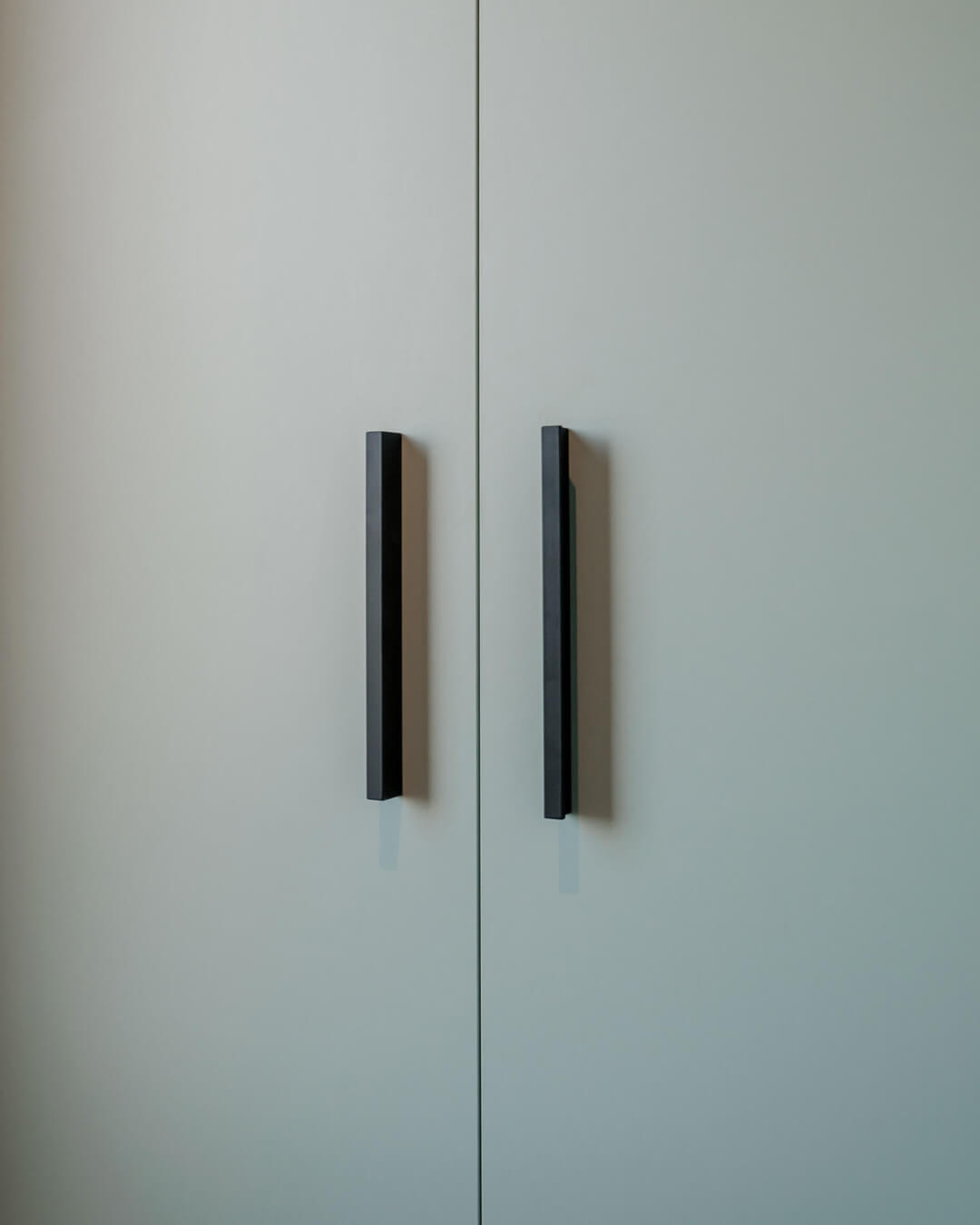 Black Bar handles on a green storage cabinet
