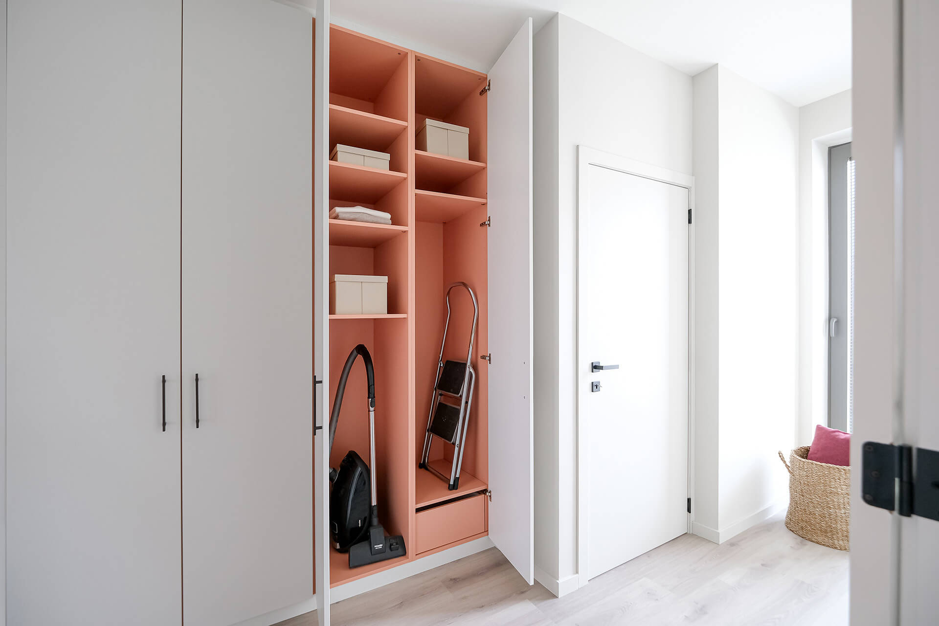 Custom storage cabinet with a pink interior from Maatkasten Online.