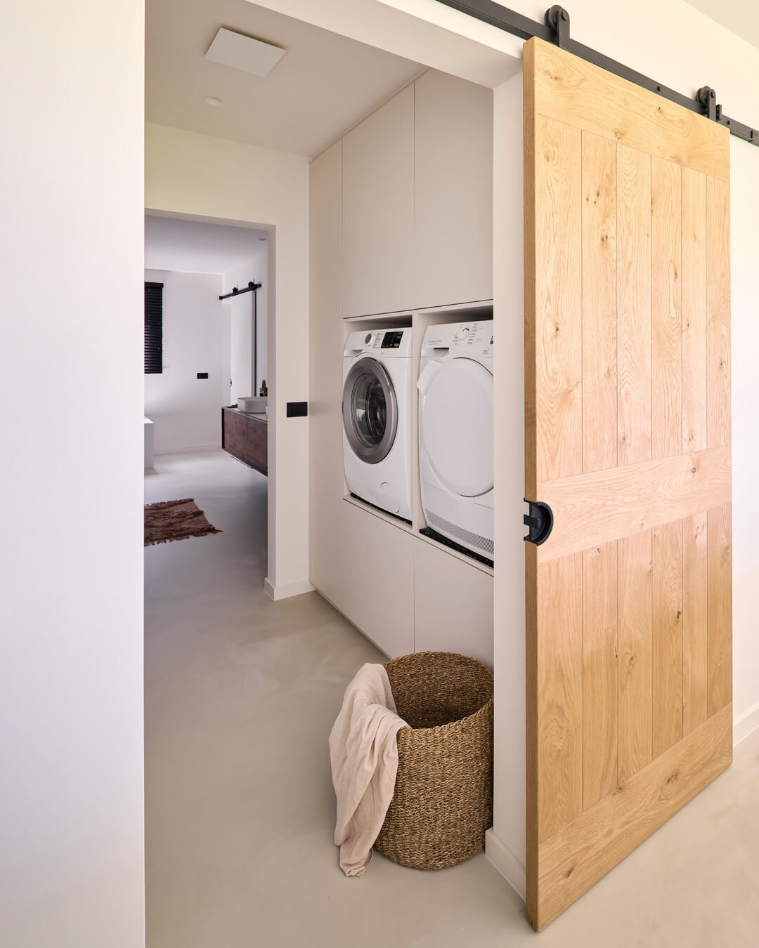 Custom laundry cabinet with built-in elevated washing appliances.