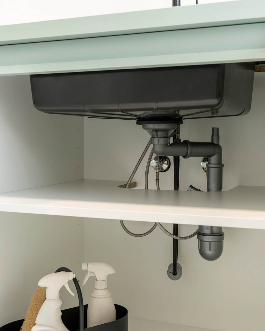 Black sink in a custom green cabinet