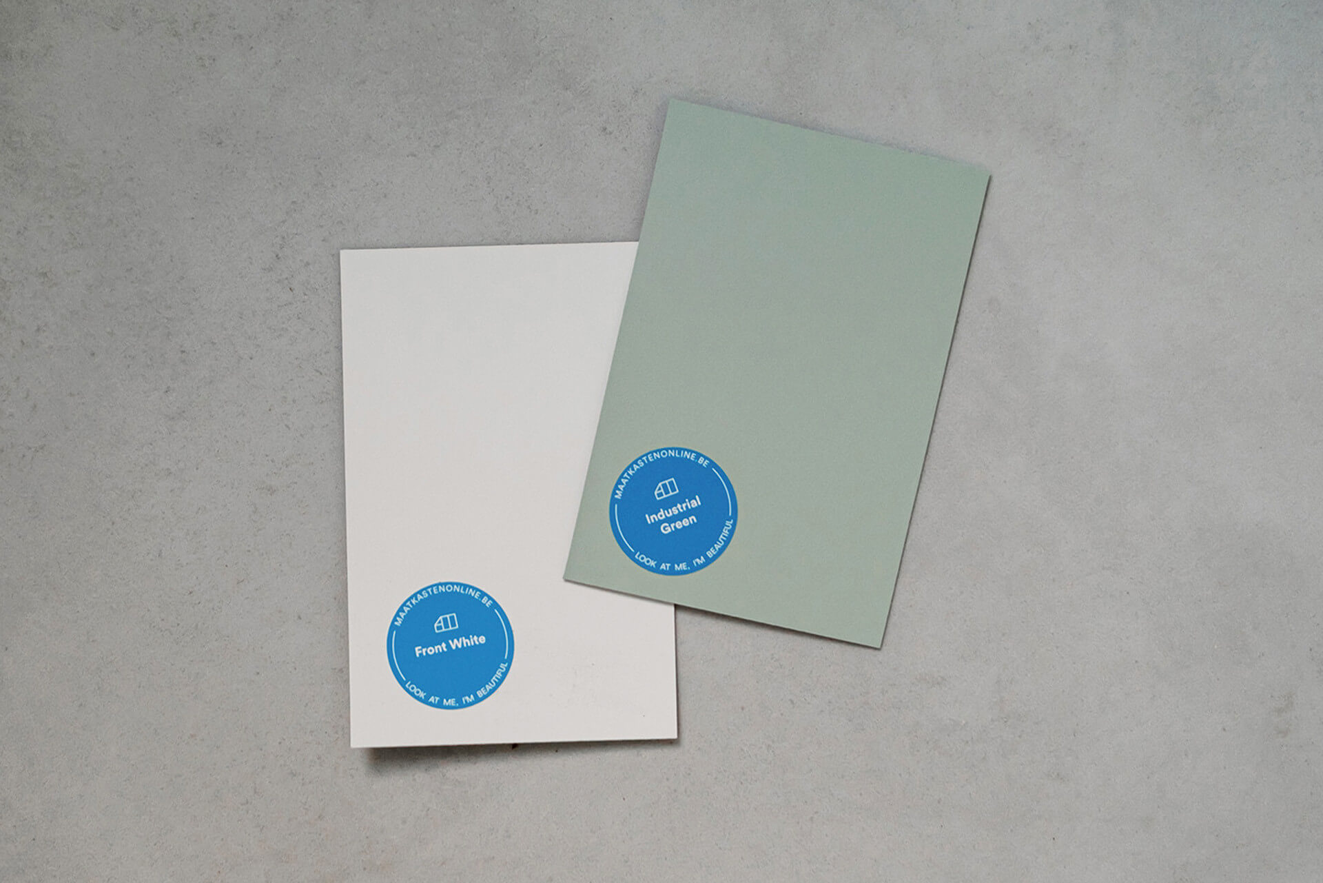 Échantillons de couleur gratuits 'Industrial Green' et 'Front White' posés sur un sol en béton