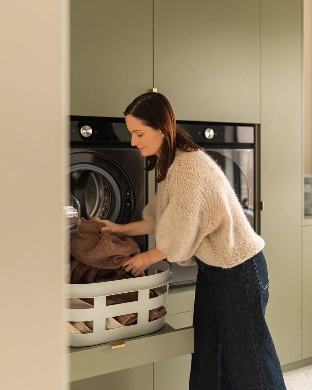 Eline unloads the washing machine in an ergonomic way thanks to the washing cabinet at height