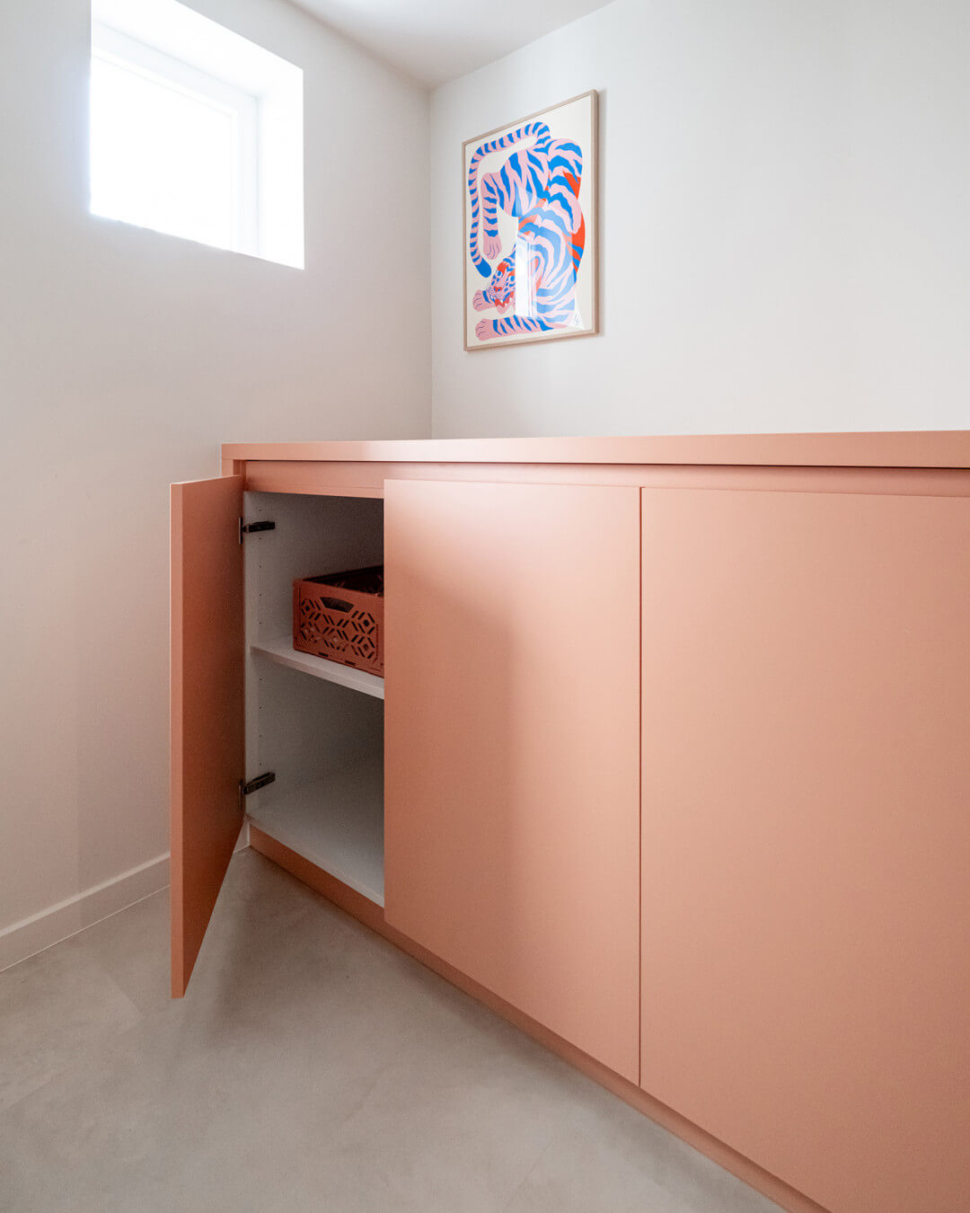 Custom-made pink storage cabinet in the laundry room of the Sundae House