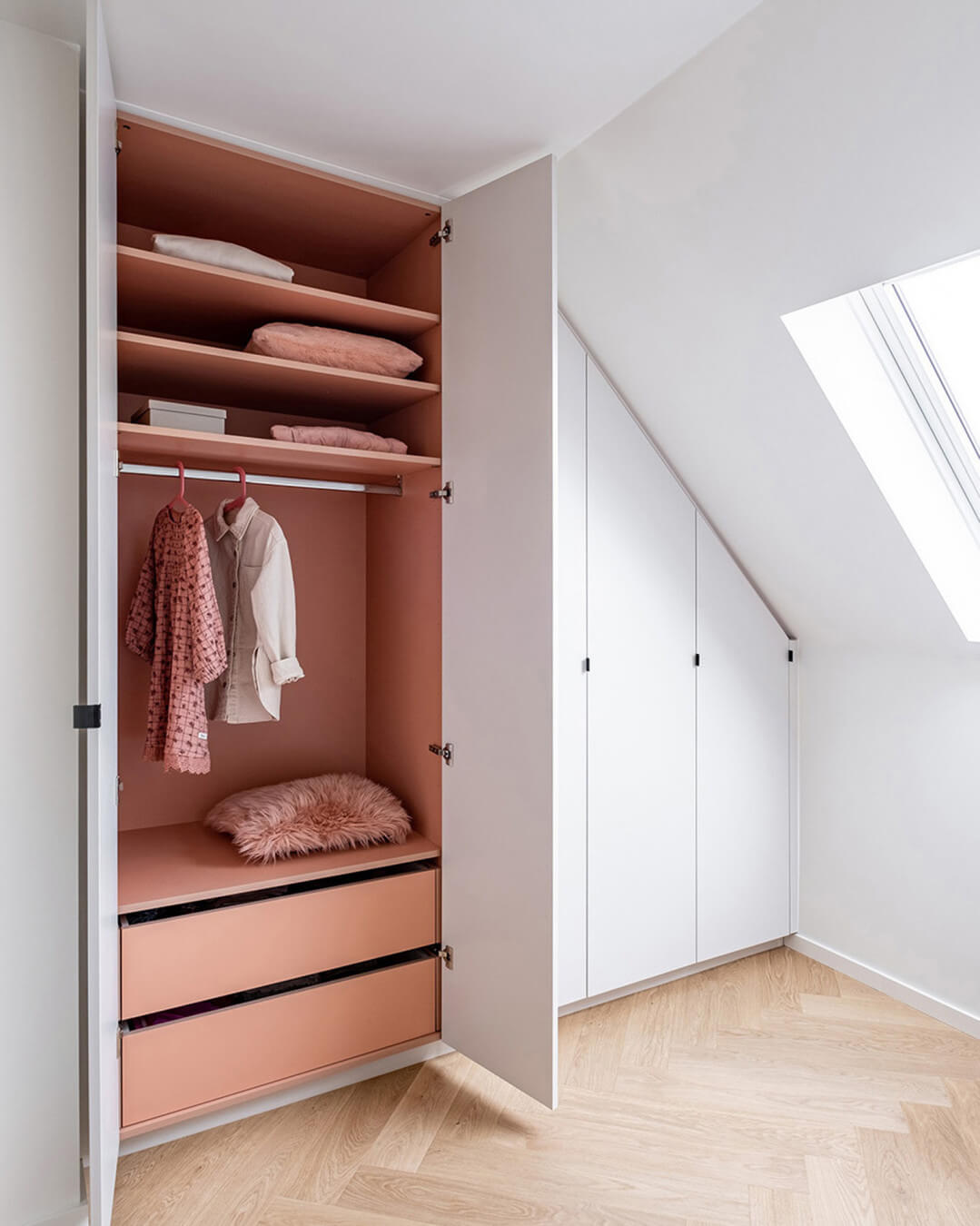 Custom-made wardrobe designed for an angled ceiling, featuring Dusty Coral as the interior color