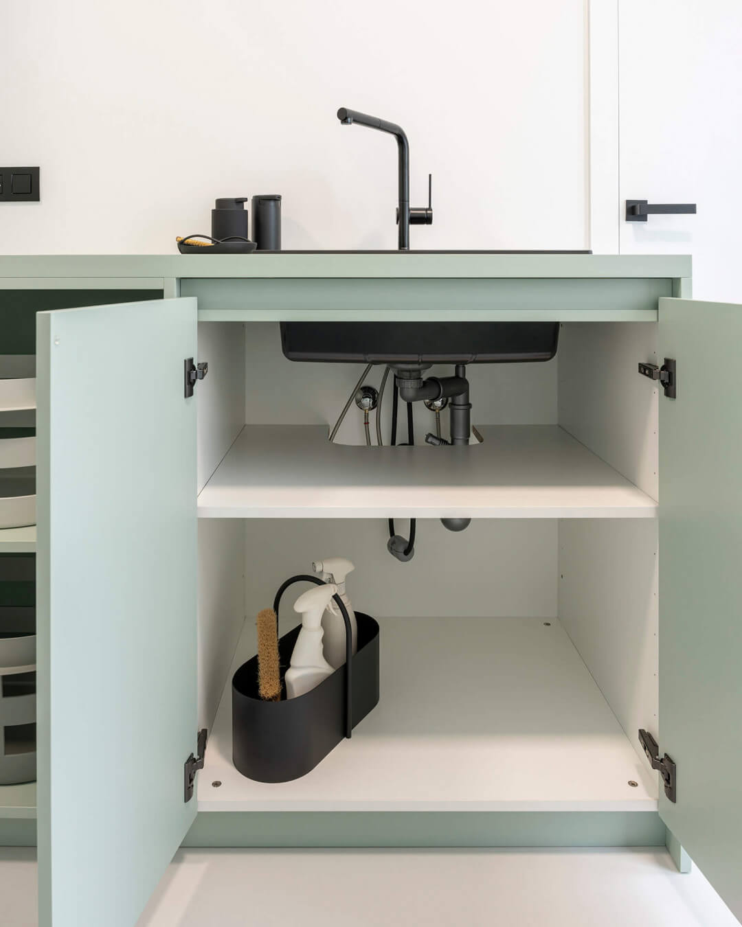 Evier noir dans un meuble vert sur mesure