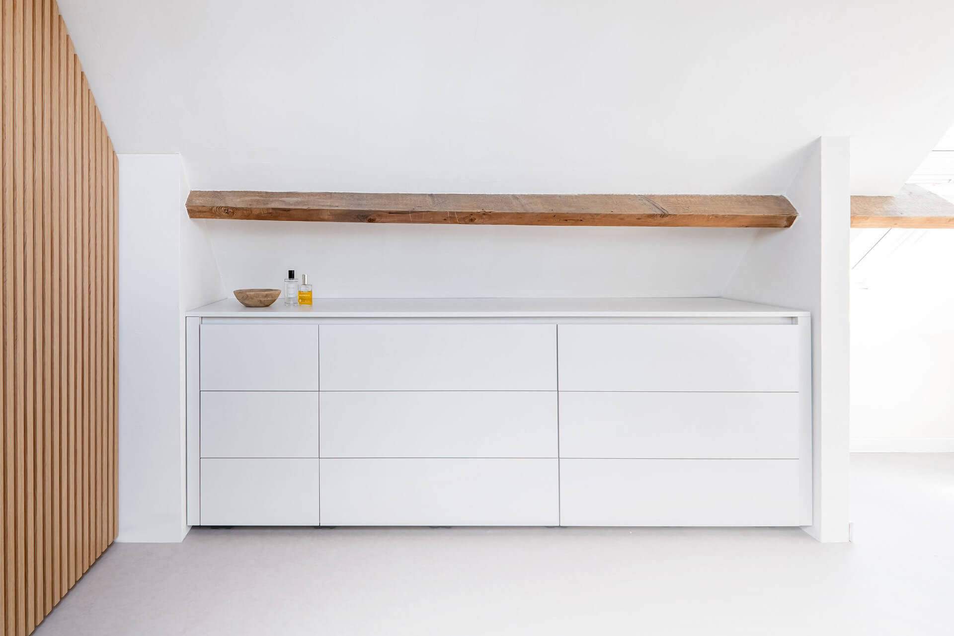 Integrated chest of drawers under a sloping roof