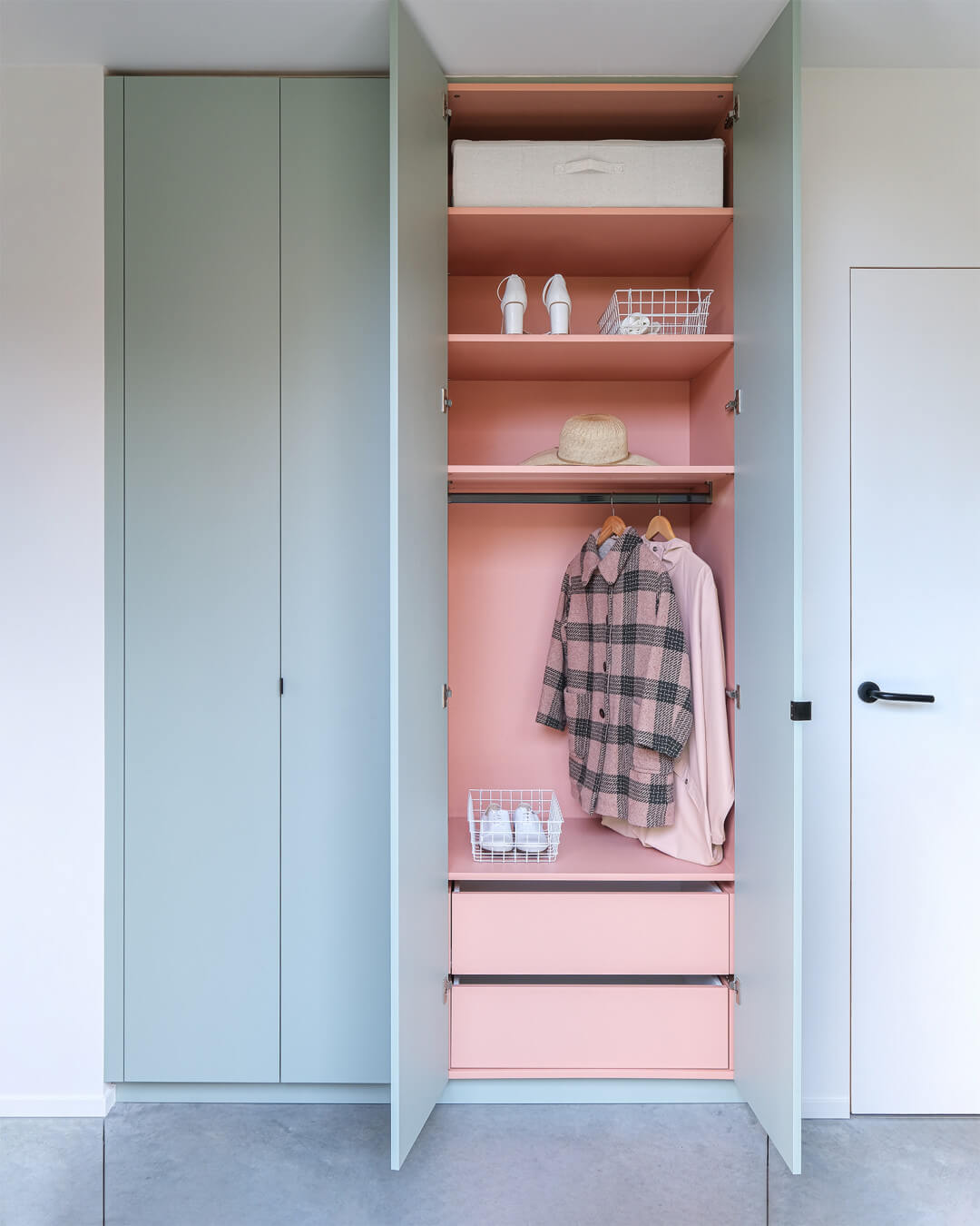 Wardrobe in the colors Industrial Green and Dusty Coral.