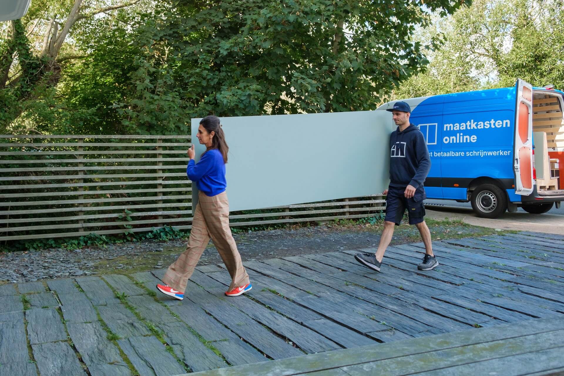 Een medewerker van Maatkasten Online lost samen met een klant de panelen van haar bestelling