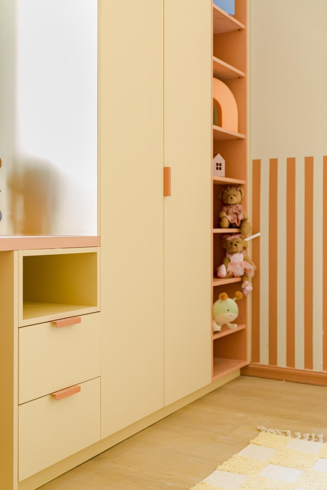 Huis Gemaakt Aalst deelnemers detailshot kinderkamer met hoge dressing op maat in Sunset en Tonton roze handgrepen met open kast in Dusty Coral en commode met Dusty Coral Bovenblad