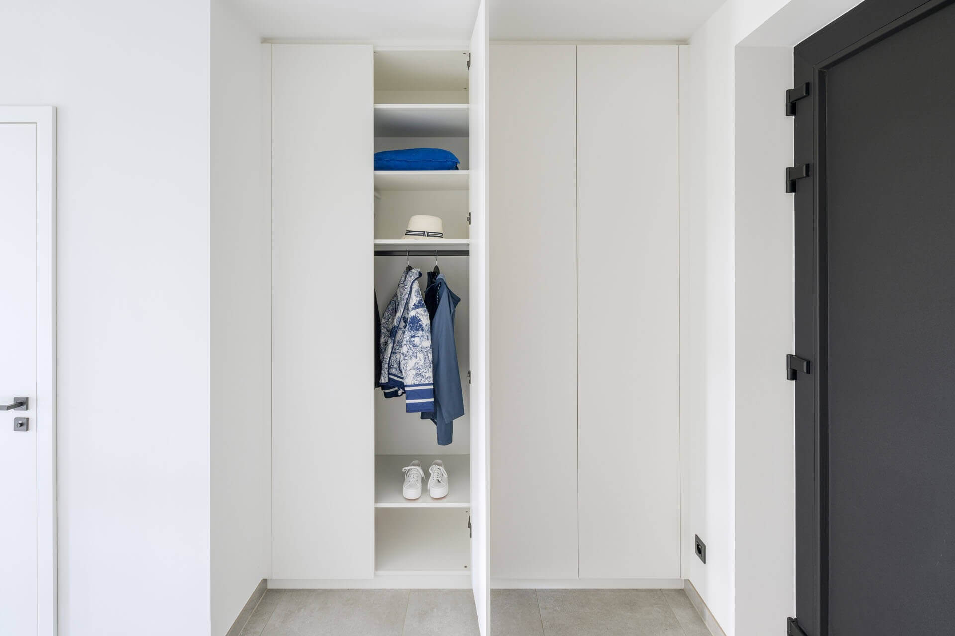 Customised white built-in storage cabinets in the entrance hall 