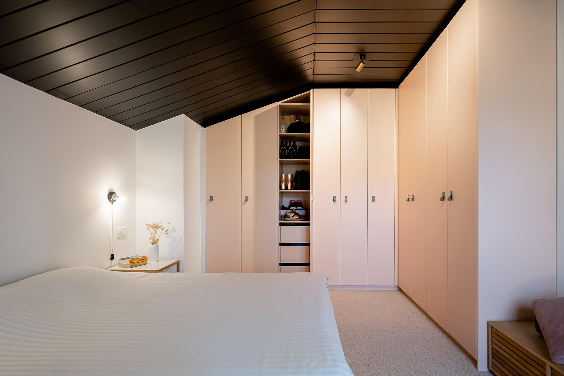 pink wardrobe in a l shape under a sloping roof