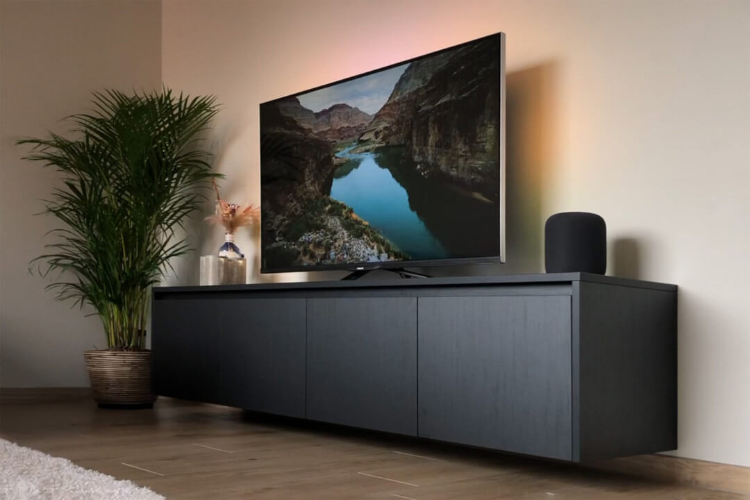 Black custom floating TV unit with handle profile, a few dozen centimetres above the floor