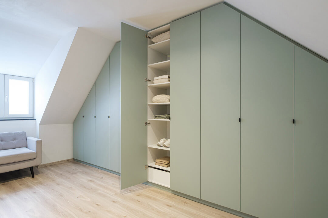Made-to-measure cupboard under sloping roof with sloping left and right side in Industrial Green colour