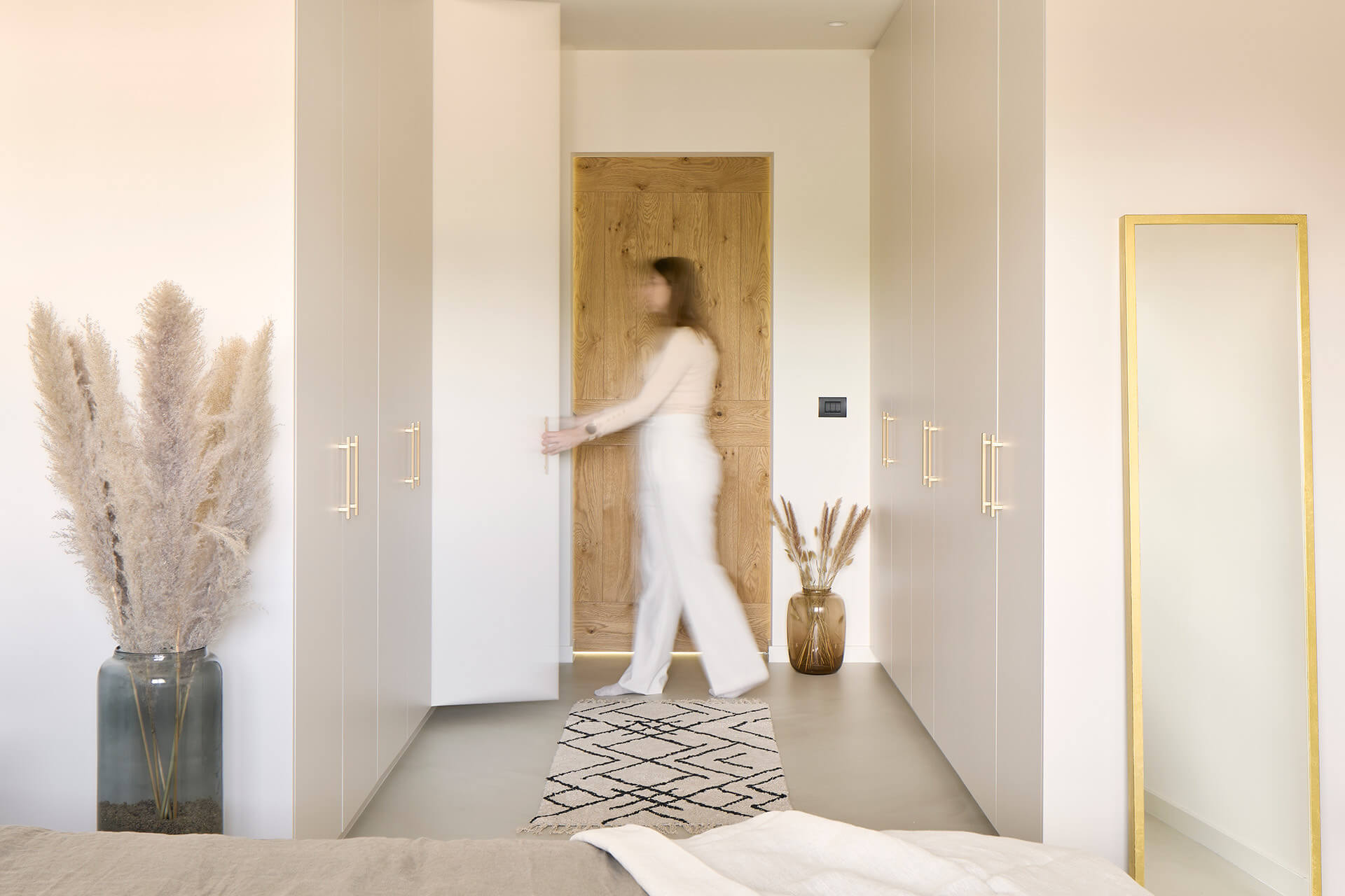 Walk-in closet in the bedroom in Seashell with golden handles.