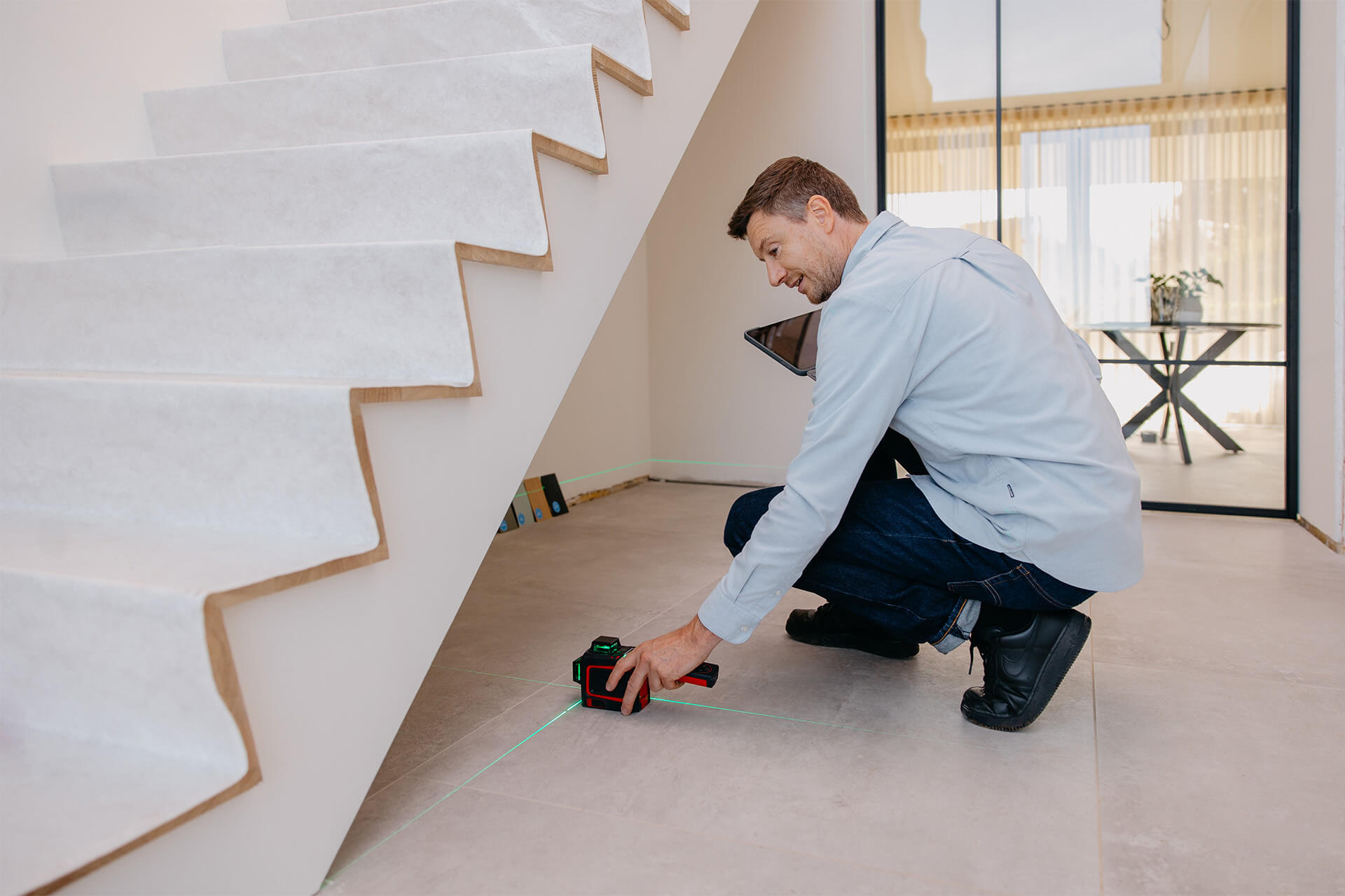 men measures room under a staircase for a made to measure storage space