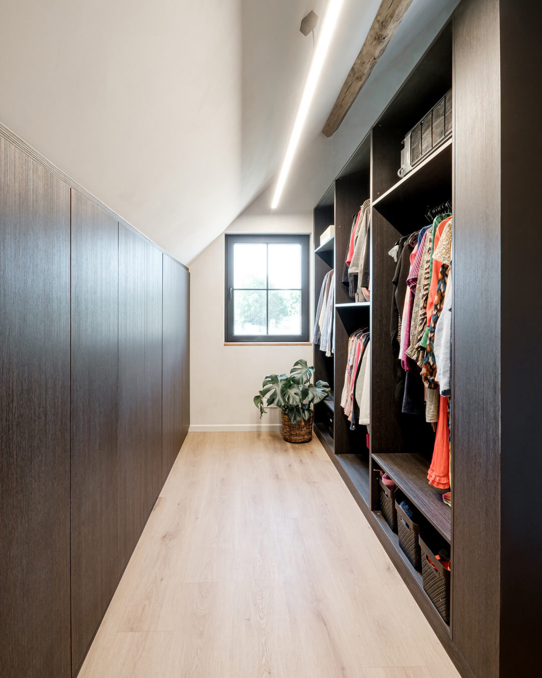 Walk-in dressing room under a sloping roof in the Hudson Oak color, from Maatkasten Online.