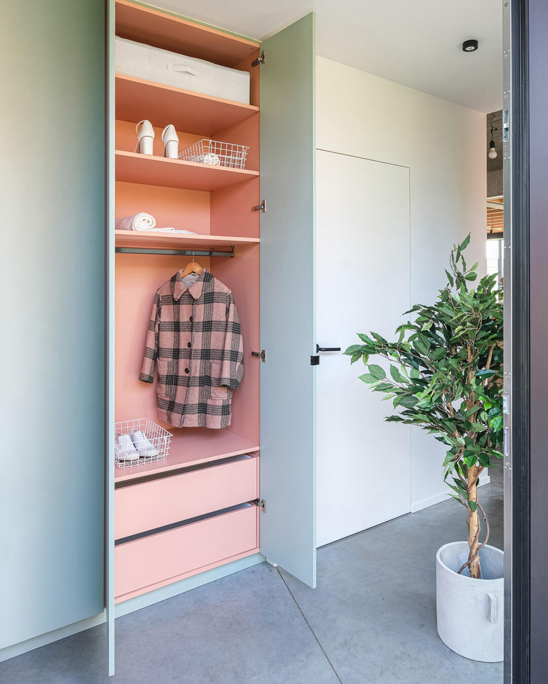 Custom wardrobe for the vestibule in industrial green with a pink interior, in a modern home