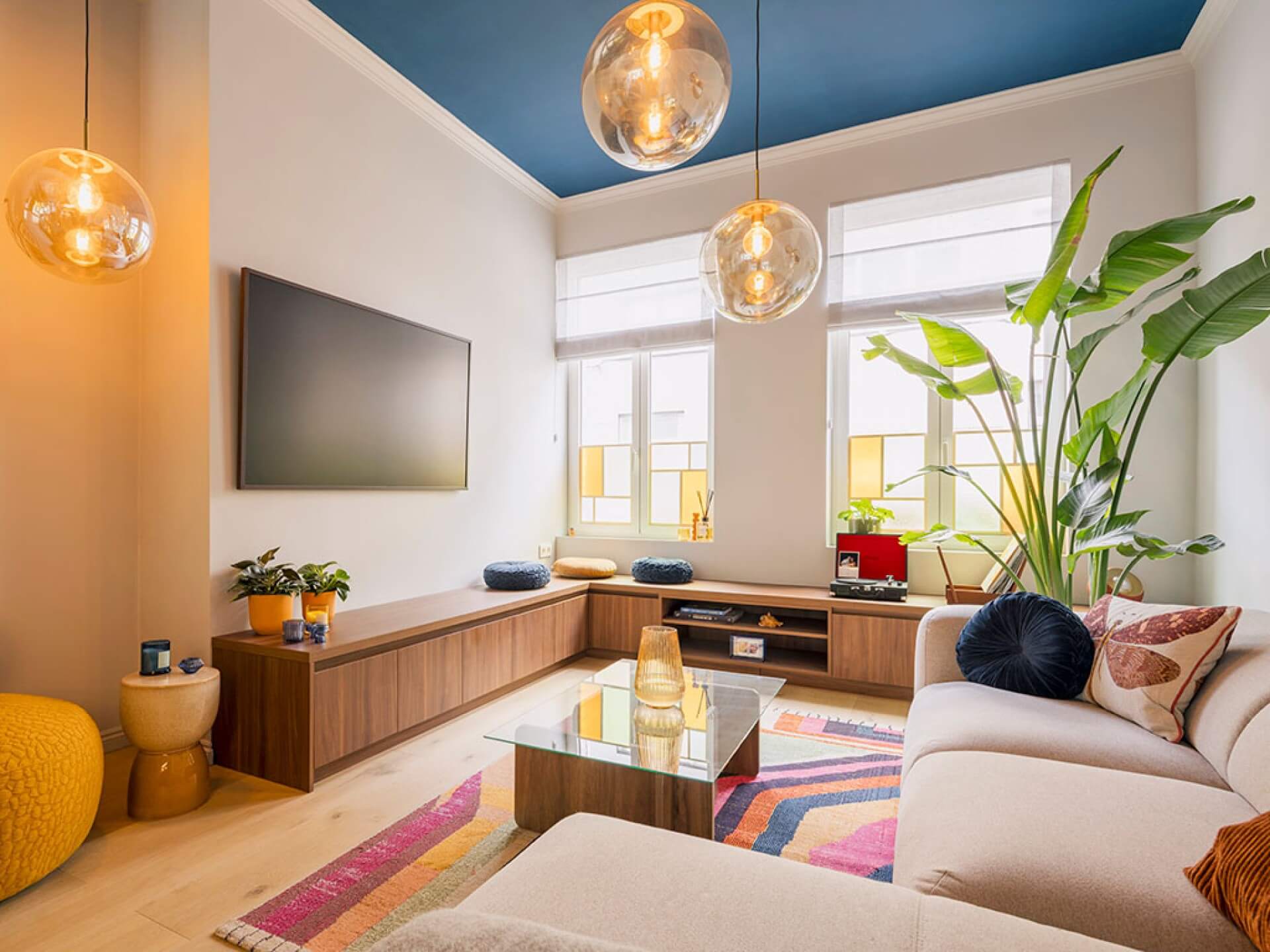 Gezellige woonkamer met een op maat gemaakt tv-meubel in een hoek in een zachte walnoot kleur
