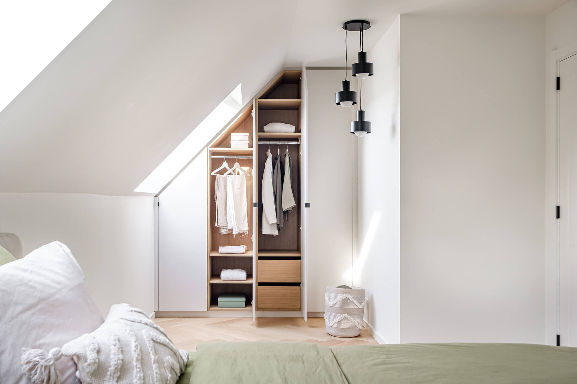 Custom wardrobe under a sloping roof with a white exterior and wooden interior