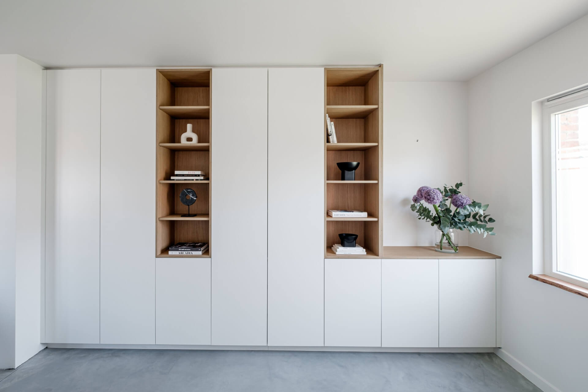 Armoire murale blanche sur mesure avec deux niches ouvertes à l’aspect bois et un meuble bas avec plateau