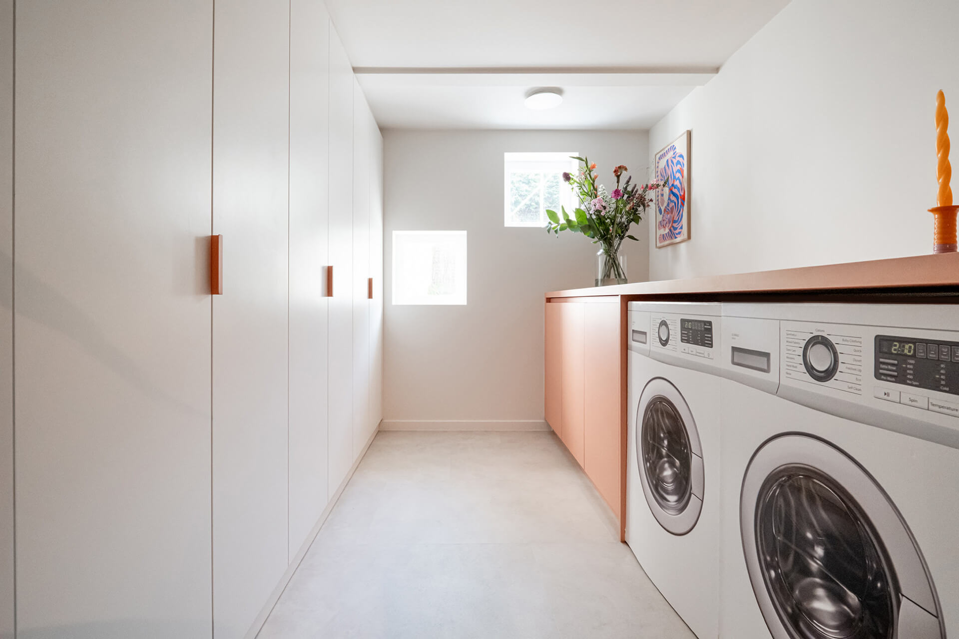 Custom white storage cabinet in a laundry room from Maatkasten Online.