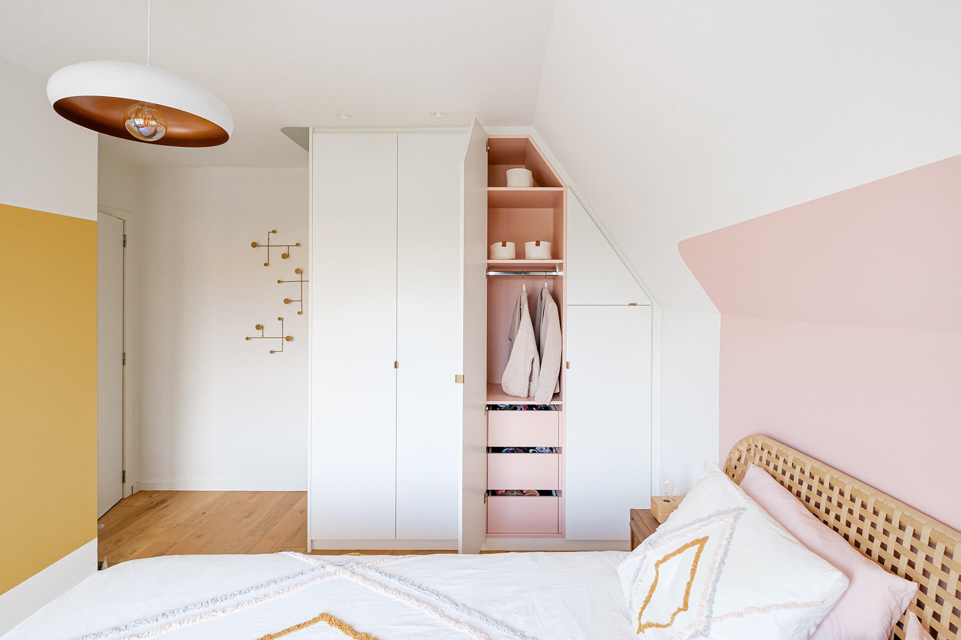 Integrated wardrobe in kids room with pink interior