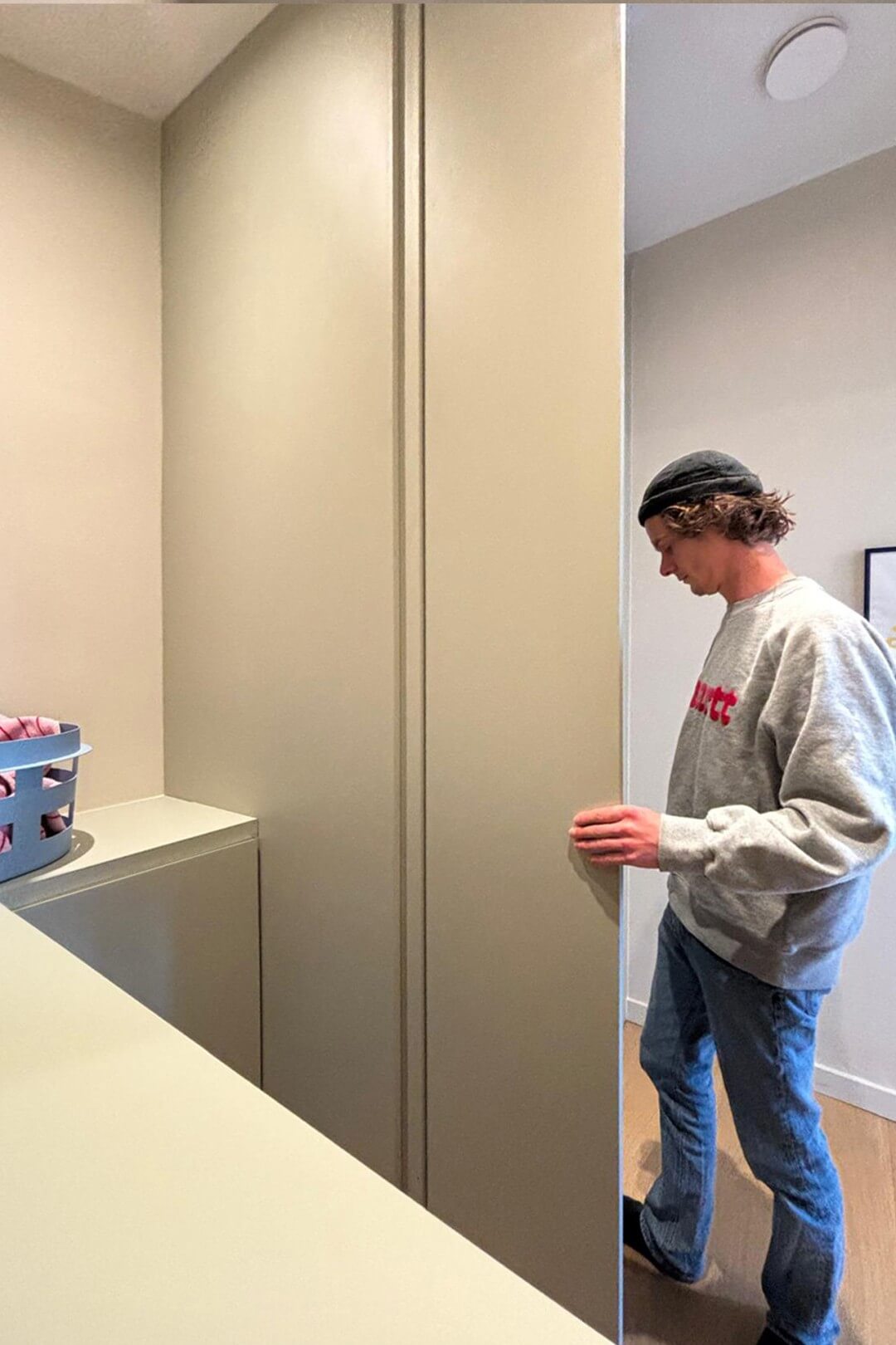 Le gagnant de Huis Gemaakt, Eros, travaille dans sa buanderie équipée d'armoires sur mesure en natural sage