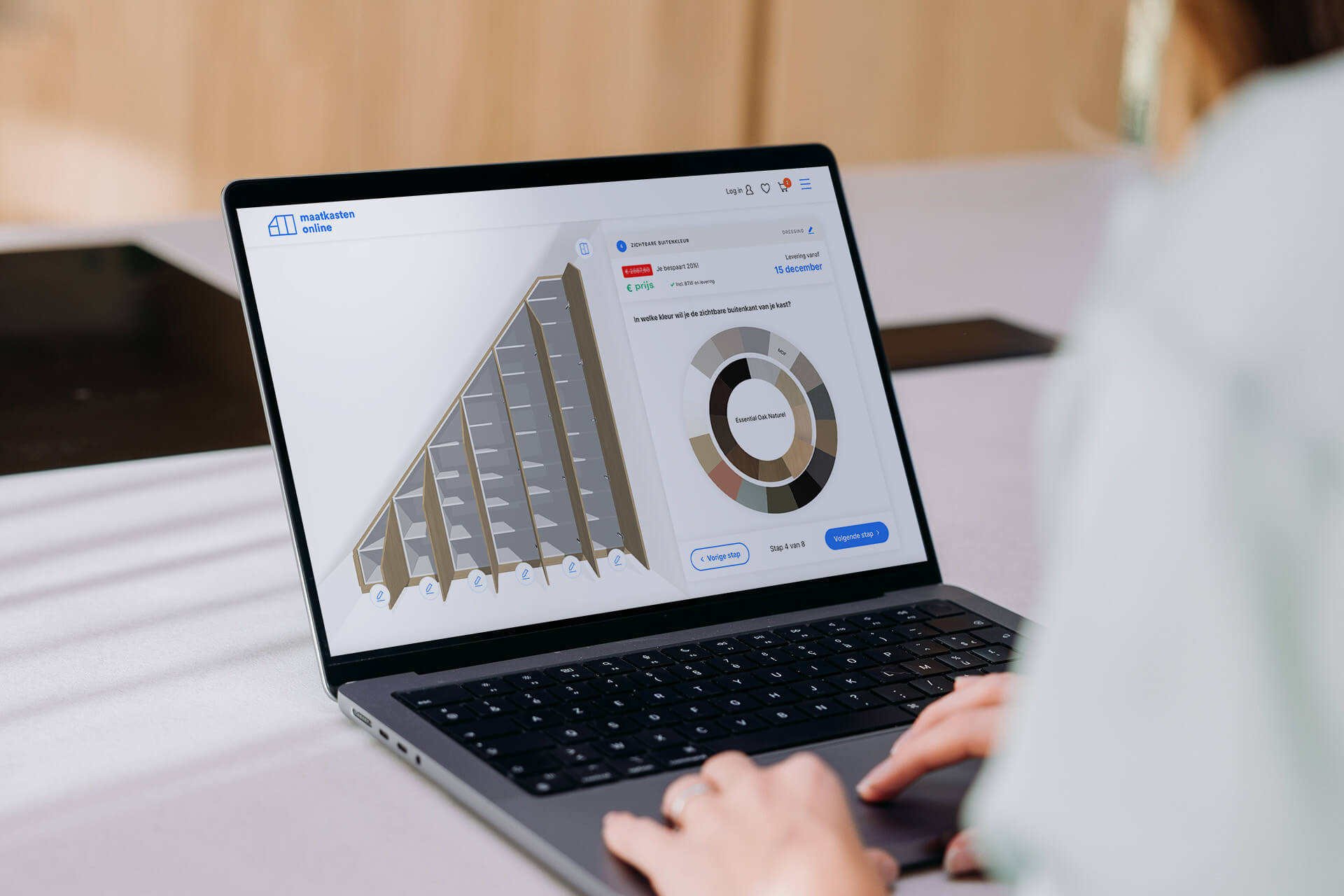 Une femme conçoit une armoire d'escalier sur un ordinateur portable dans le configurateur 3D de Maatkastenonline