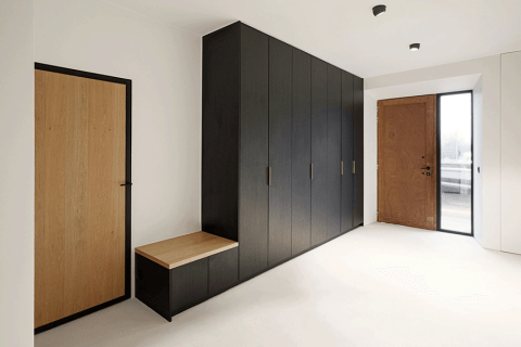 Pure messing handgrepen op een op maat gemaakte halkast met zitbank in Elegant Black.