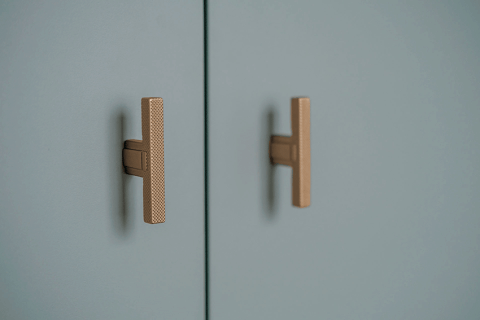 Detail shot van de T-Diamond handgrepen in Messing op een op maat gemaakte opbergkast in Industrial Green.