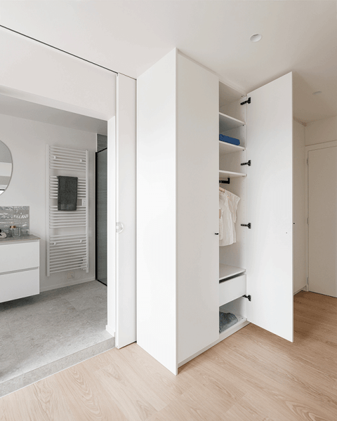 Kledingkast op maat in Front White met Olive handgrepen in het zwart. De rechtse deur van de kledingkast staat open.