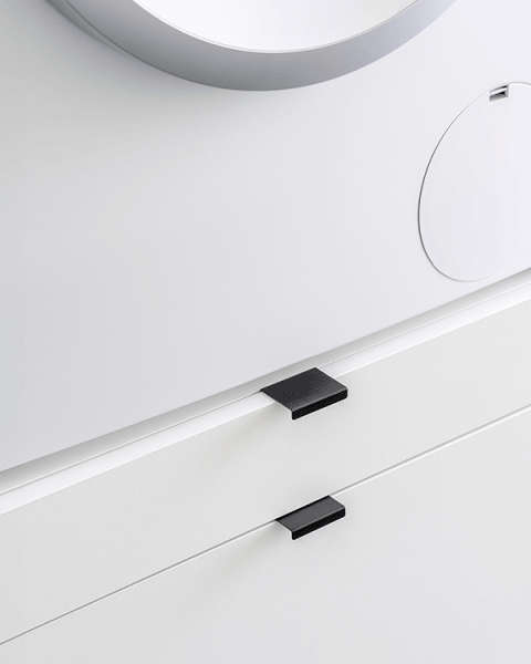 Detail shot van een Front White op maat gemaakte wasmachine kast waarop zwarte Mini Pure handgrepen werden gemonteerd.