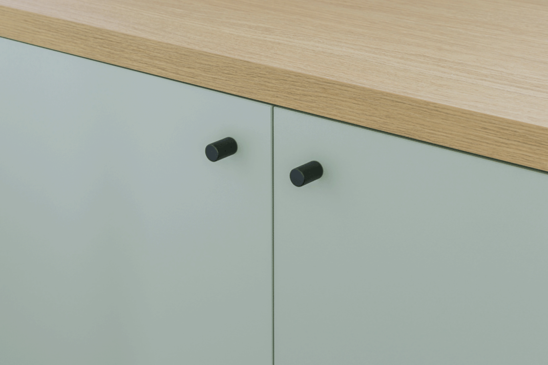 Gros plan sur les poignées Monument noires sur une armoire sur mesure en Industrial Green.