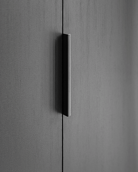 Pure handgreep in zwart op een maatkast in Elegant Black. Detail shot van de handgreep op een dressing op maat.