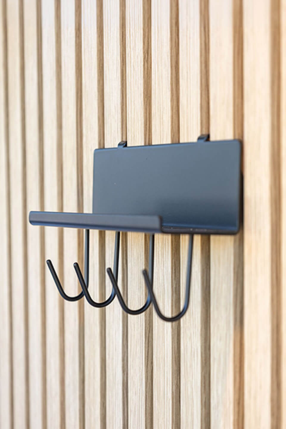 Rechter zijaanzicht van een wandplank met haakjes op akoestische wandpanelen. Verkrijgbaar in de Maatkasten Online boetiek.