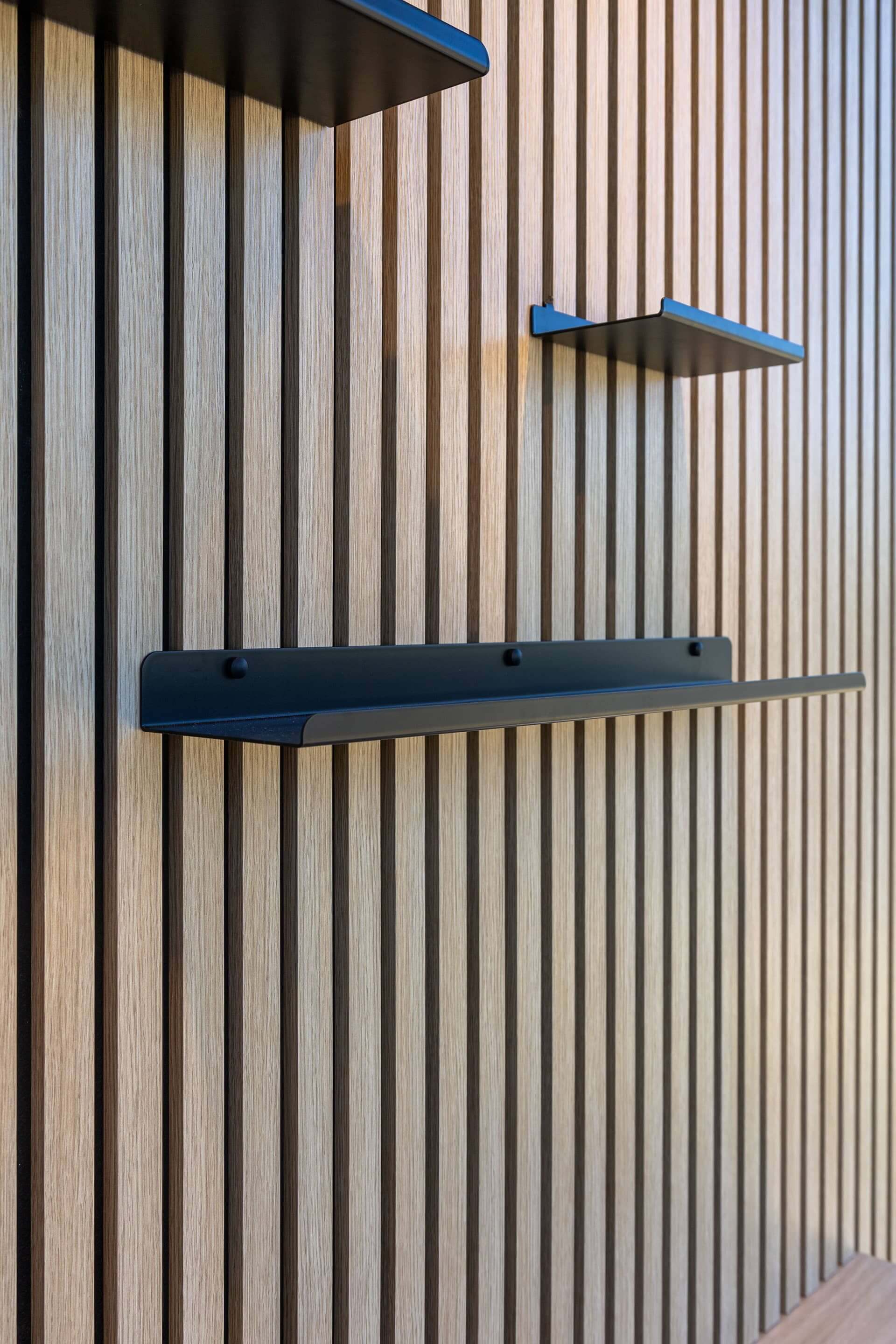 Vue latérale d'une grande étagère murale sur panneaux acoustiques. Disponible dans la boutique en ligne de Custoro.