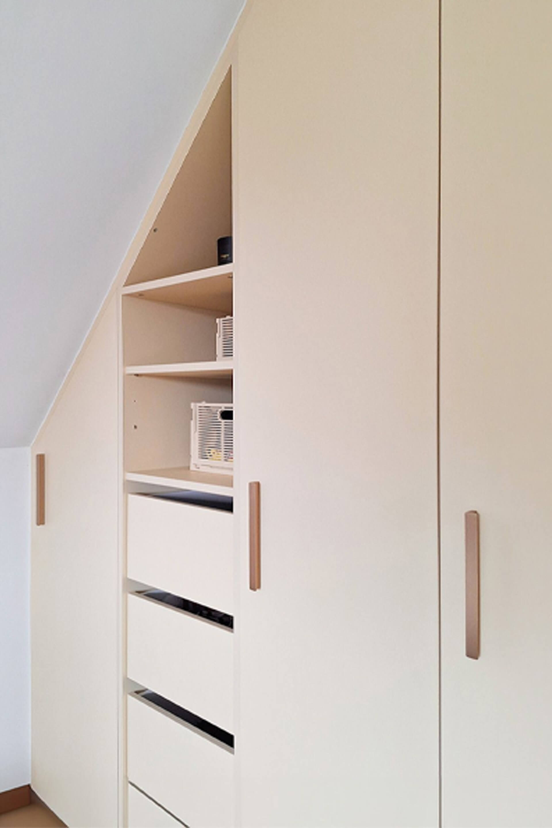 Detail shot of white custom-made slanted dressing cabinet with brass Bar handles
