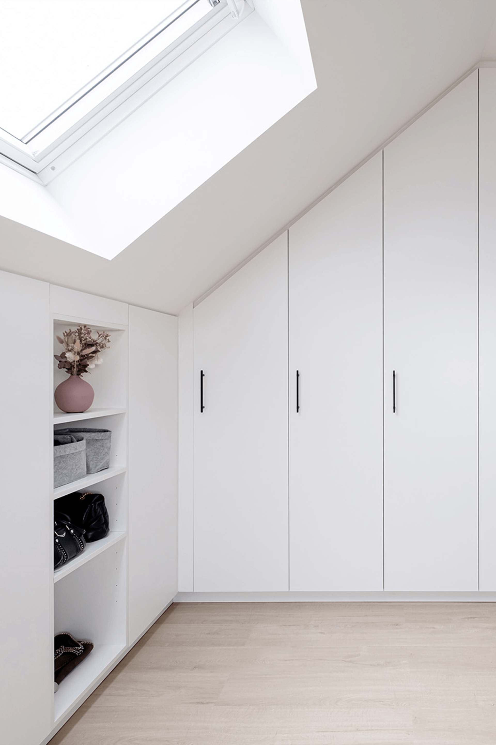 Zwarte Diamond handgrepen op een witte zolder kledingkast op maat. Schuine wand kast op maat.