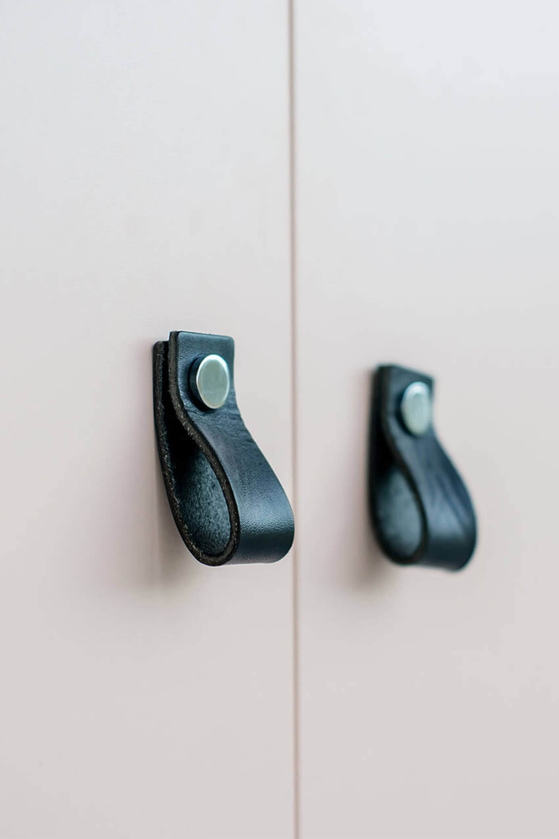 Detail shot of a white cabinet with black Leather Loop handles