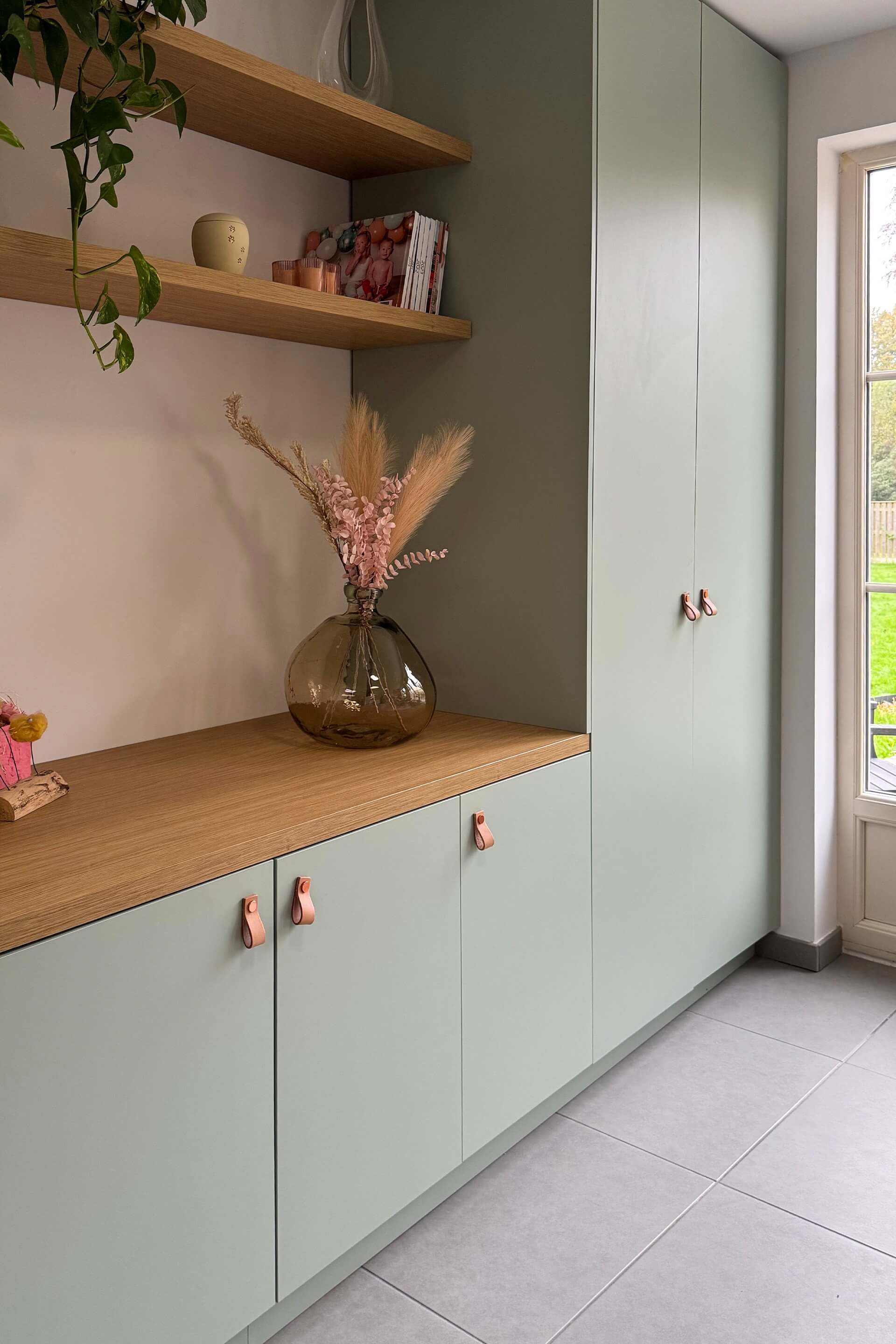 Combinaison de meubles muraux sur mesure, de couleur Industrial Green, avec poignées Leather Loop en cuivre.