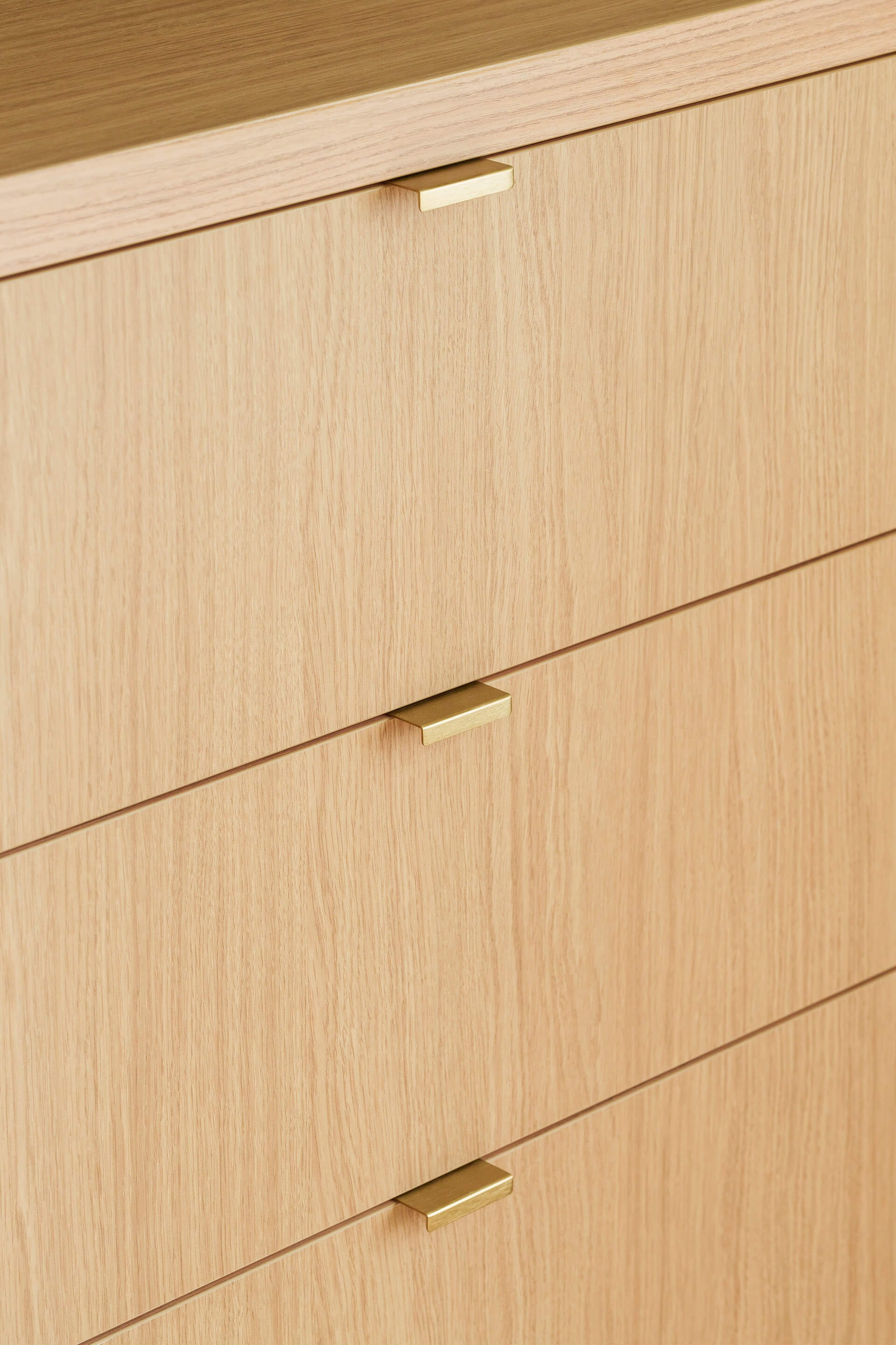 Foto van een dressoir op maat met messing Mini Pure handgrepen. De Mini Pure handgrepen zijn horizontaal gemonteerd aan de lades.