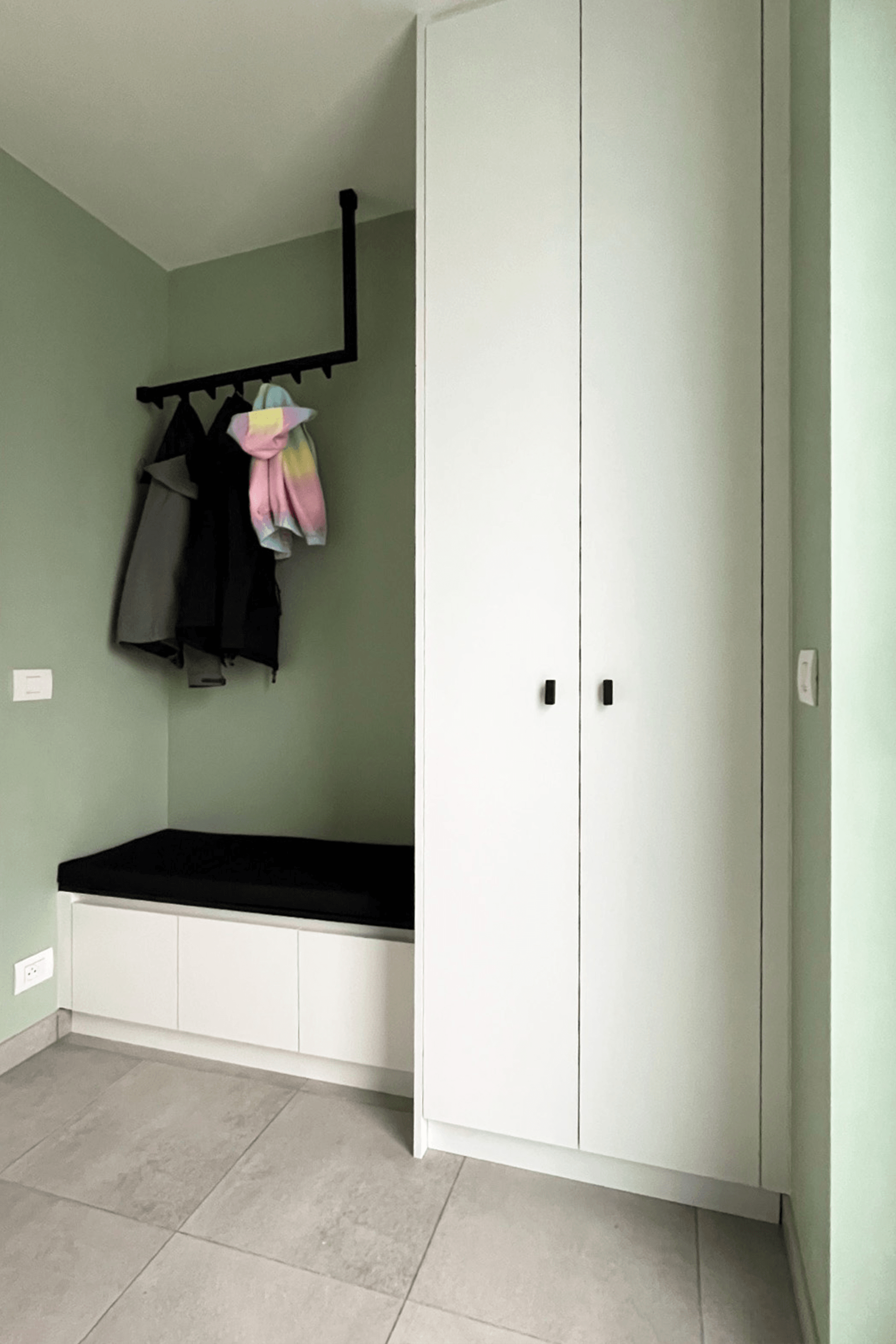 Meuble d'entrée sur mesure avec banquette, façade blanche et poignées Mini Bar noires.