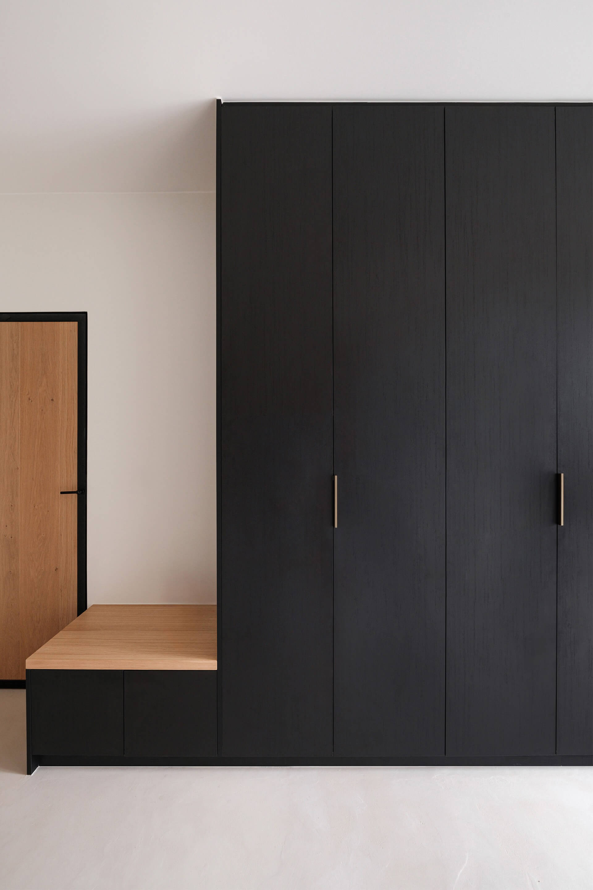 Pure messing handgrepen op een op maat gemaakte halkast met zitbank in Elegant Black.
