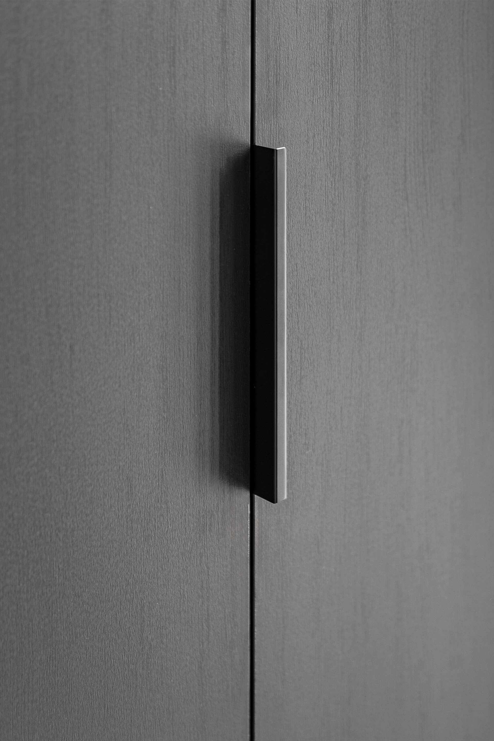Pure handgreep in zwart op een maatkast in Elegant Black. Detail shot van de handgreep op een dressing op maat.
