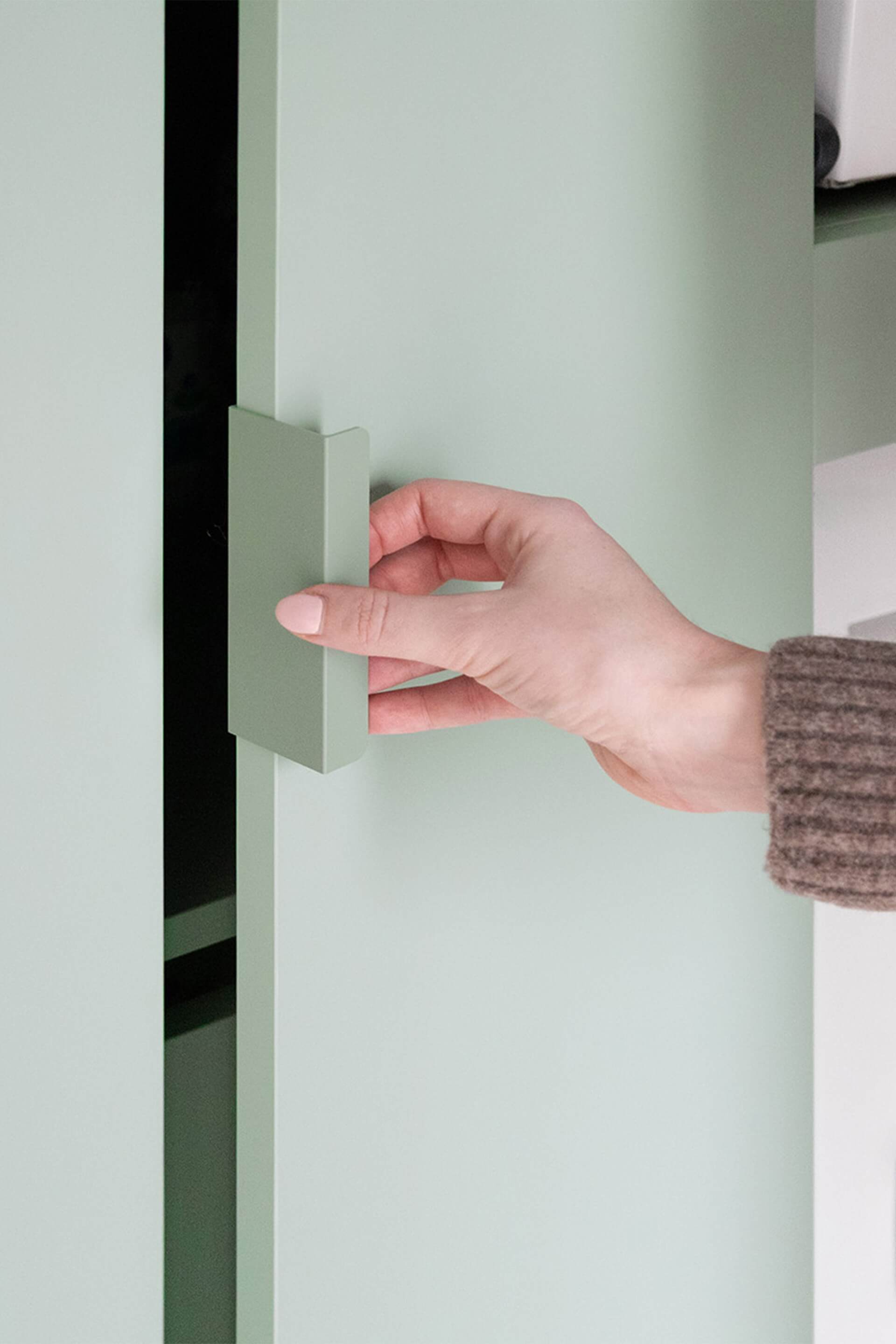 Detail shot van groene Tonton handgrepen op een groene op maat gemaakte kast van Maatkasten Online