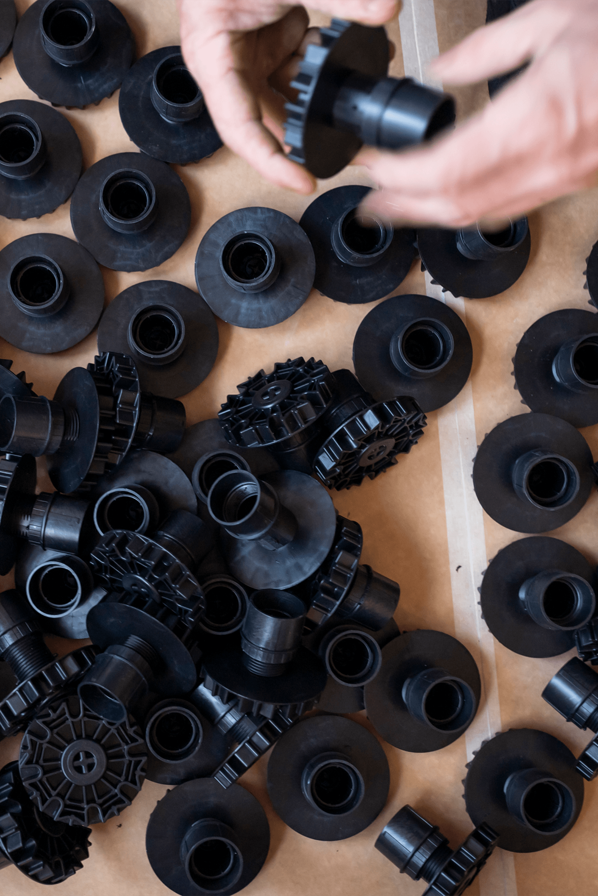 Op deze foto zie je een verzameling zwarte sokkelpoten van 60 mm, afkomstig uit de boetiek van Maatkasten Online. Deze stevige kunststof poten worden gebruikt als onderstel voor maatkasten, zorgen voor een stabiele plaatsing en zijn eenvoudig verstelbaar. De close-up toont zowel de bovenkant als het tandwielsysteem dat voor een nauwkeurige afstelling zorgt.